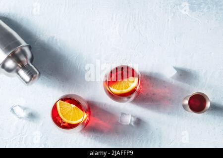 Negroni Cocktails mit Campari, aperol, Orangen, einem Shaker und einem Jigger, Top Shot mit Eiswürfeln Stockfoto