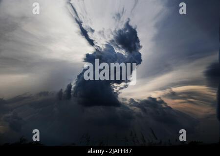 DAS UMGEKEHRTE AUGE: Ein kreativer Geist, der sich einer bedrohlichen Schurkensturmwolke am Abendhimmel nachstellt. Stockfoto