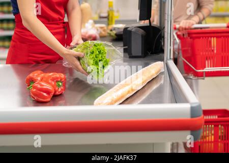 Unkenntlich Frau kauft Lebensmittel in modernen Supermarkt, Kassiererin piepst sie Stockfoto