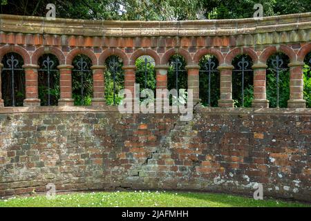 Dekorative gebogene Ziegelwand mit Bögen und Säulen und Schmiedeeisen Stockfoto