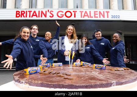 REDAKTIONELLE VERWENDUNG NUR Baker, Frances Quinn (Mitte) und die britischen Got Talent-Crew verteilen vor dem Eventim Apollo in London Scheiben des „größten Jaffa-Tortes“ des Guinness-Weltrekords, um McVitie's Hauptsponsor des 15.-jährigen Bestehens von Got Talent, London, zu feiern. Bilddatum: Montag, 30. Mai 2022. Stockfoto