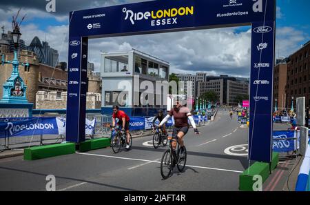 Ein Radsportler, der an der RideLondon 2022 teilnimmt, streckt seine Arme aus, als er die Ziellinie auf der Tower Bridge in London überquert. Die Veranstaltung fand für Th statt Stockfoto