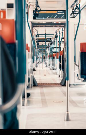 Moderne Innenausstattung des Zuges. Perspektive eines leeren Personenzugwagens. Reihen mit nicht belegten Sitzen Stockfoto