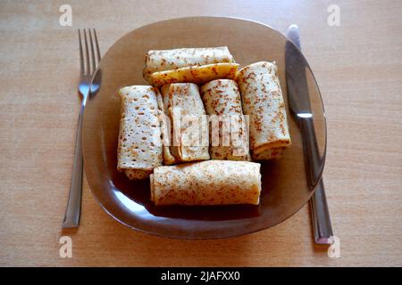 Viele Pfannkuchen auf einem Teller auf dem Tisch. Kochen und Essen zu Hause Stockfoto