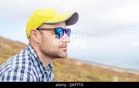 Ein junger Mann mit Mütze und Brille. Stockfoto