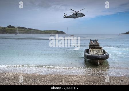 Ein Offshore Raiding Craft Marines ORC und ein Royal Navy Merlin Hubschrauber in Polgwidden Cove zum jährlichen Military Day im Trebah Garden in Cornwall i Stockfoto