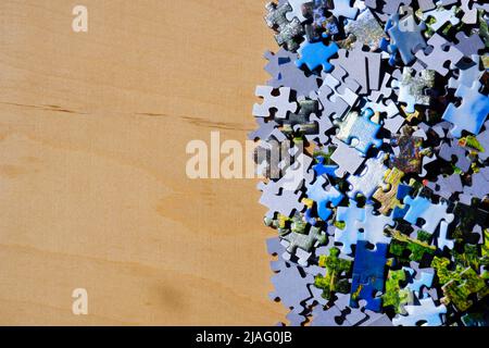 Verstreute Puzzleteile auf einem Holztisch Stockfoto