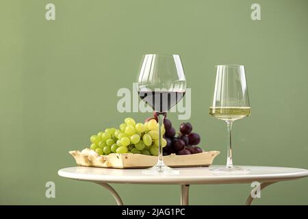 Gläser Weiß- und Rotwein mit Trauben Stockfoto
