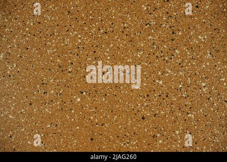 Textur aus poliertem braunem Granit mit schwarzen und weißen Spritzern Stockfoto