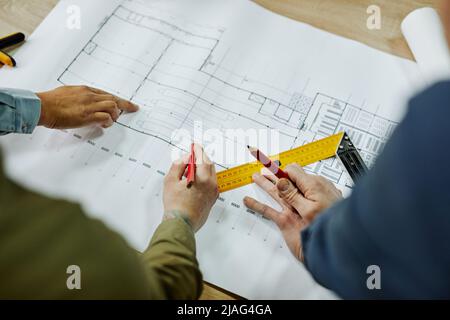 Draufsicht Nahaufnahme von zwei Architekten, die über Boden- und Möbelpläne diskutieren, Platz kopieren Stockfoto