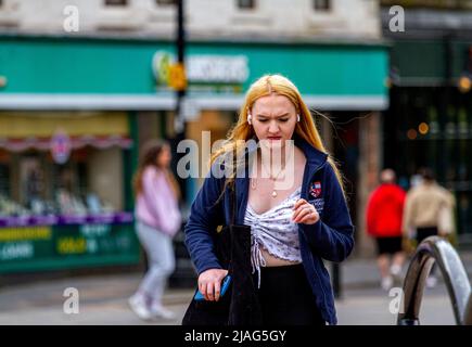 Dundee, Tayside, Schottland, Großbritannien. 30.. Mai 2022. UK Wetter: Ein heller und glamouröser Tag in Dundee, mit Temperaturen bis zu 15 Grad Tagsüber sind einige modische und glamouröse Frauen im Stadtzentrum unterwegs, genießen das Wetter und verbringen den Tag mit geselligen Einkäufen. Eine hübsche blonde junge Dame geht mehrmals umher, um sich fotografieren zu lassen. Kredit: Dundee Photographics/Alamy Live Nachrichten Stockfoto