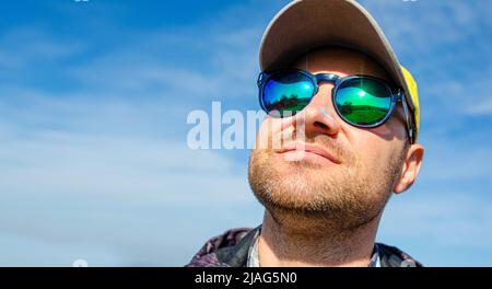 Ein junger Mann mit Mütze und Brille. Stockfoto