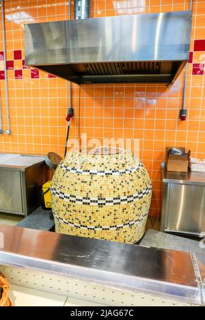 Großer Tandoor-Ofen zur Herstellung von flachem ungesäuertem Weißbrot in Form eines dünnen Fladenbrotes aus Weizenmehl. Der Ofen ist im Laden Stockfoto