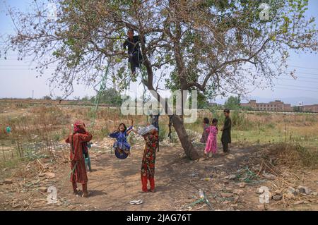 Islamabad, Pakistan. 29.. Mai 2022. Afghanische Flüchtlingskinder spielen am 29. Mai 2022 in einem Vorort von Islamabad, Pakistan, auf einer lokalen Schaukel. (Foto: Raja Imran/Pacific Press/Sipa USA) Quelle: SIPA USA/Alamy Live News Stockfoto