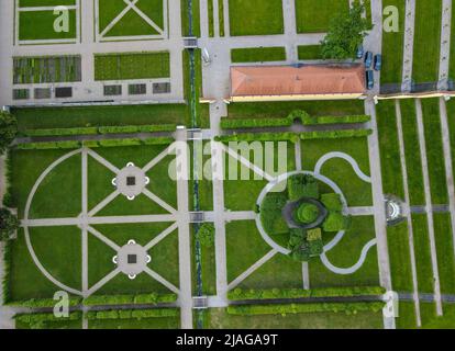 30. Mai 2022, Brandenburg, Neuzelle: Der Klostergarten des Klosters Neuzelle (Luftaufnahme mit Drohne). Im Klostergarten Neuzelle im oder-Spree-Kreis laufen seit rund zwei Jahren die Arbeiten an der dritten und letzten Bauphase zur Sanierung des Barockgeländes. Die Eröffnung ist für 10.06.2022 geplant. Hier entstanden eine Baumschule mit Gewächshaus, Küchengarten und Kräutergarten sowie symmetrisch angelegte Blumenbeete, die mit Hecken und Obstbäumen gesäumt sind. Seit 1998 wird an dem fast 5 Hektar großen Gartenkomplex gearbeitet, der sich als Konsid gilt Stockfoto