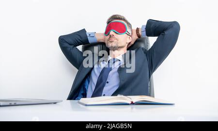 Müde Regisseur entspannen in Schlafmaske am Arbeitsplatz Stockfoto