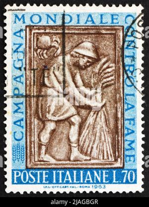 ITALIEN - UM 1963: Eine in Italien gedruckte Briefmarke zeigt Harvester-Binde-Garbe, Skulptur aus dem Maggiore-Brunnen, Perugia, Freiheit für Hunger, um 196 Stockfoto