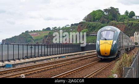 Dawlish, England - 12. Mai 2022: Ein Personenzug der Great Western Railway, der nach London Paddington fährt, nähert sich dem Bahnhof Dawlish an der Küste Stockfoto