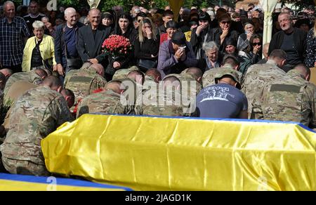 Non Exclusive: VINNYZJA, UKRAINE - 29. MAI 2022 - Soldaten knien neben den Särgen mit den Leichen von neun KORD-Soldaten, die in einem russischen M umkamen Stockfoto