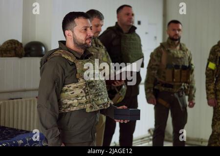 Der Präsident der Ukraine, Wolodymyr Zelenski, besuchte während einer Arbeitsreise in die Region Charkiw die Frontpositionen des ukrainischen Militärs. Der Staatschef machte sich mit der operativen Situation im Zuständigkeitsbereich der entsprechenden Einheiten vertraut. Wolodymyr Zelenski überreichte den Soldaten staatliche Auszeichnungen und Geschenke und sprach mit den Verteidigern der Ukraine. „Ich möchte jedem von Ihnen für Ihren Dienst danken. Sie riskieren Ihr Leben für uns alle und unseren Staat. Vielen Dank, dass Sie die Unabhängigkeit der Ukraine verteidigt haben. Passen Sie auf sich auf!“ Sagte der Präsident. Stockfoto