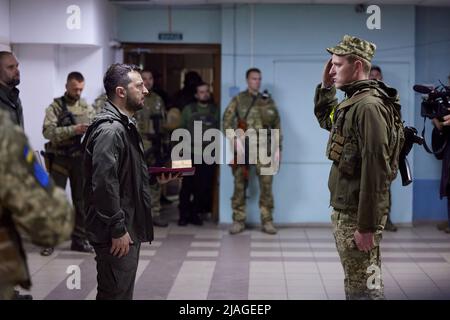 Der Präsident der Ukraine, Wolodymyr Zelenski, besuchte während einer Arbeitsreise in die Region Charkiw die Frontpositionen des ukrainischen Militärs. Der Staatschef machte sich mit der operativen Situation im Zuständigkeitsbereich der entsprechenden Einheiten vertraut. Wolodymyr Zelenski überreichte den Soldaten staatliche Auszeichnungen und Geschenke und sprach mit den Verteidigern der Ukraine. „Ich möchte jedem von Ihnen für Ihren Dienst danken. Sie riskieren Ihr Leben für uns alle und unseren Staat. Vielen Dank, dass Sie die Unabhängigkeit der Ukraine verteidigt haben. Passen Sie auf sich auf!“ Sagte der Präsident. Stockfoto