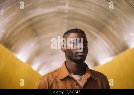 Porträt eines jungen Mannes, der im U-Bahn-Tunnel steht Stockfoto