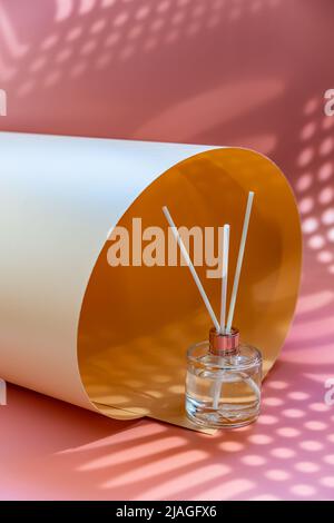 Aroma Schilf Diffusor, Home Duftflasche mit Rattan Sticks und Geruch von Frische auf rosa Hintergrund mit hellen Schatten Stockfoto