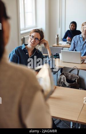 Studentin im Gespräch mit dem Lehrer während der Vorlesung im Klassenzimmer Stockfoto