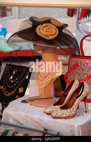Eleganter breiter Krempe Vintage Damenhut auf Schaufensterpuppe Kopf mit Perlen und hohen Absätzen Schuhe an der Seite am Wochenende Flohmarkt. Nahaufnahme des Bildes. Stockfoto