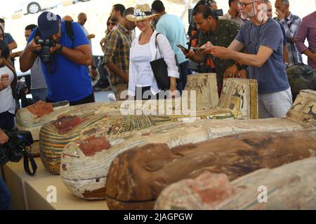 Kairo, Ägypten. 30.. Mai 2022. Am 30. Mai 2022 fotografieren Menschen bei einer Ausstellung archäologischer Errungenschaften in der Nekropole von Saqqara, südlich von Kairo, Ägypten, farbige Särge mit Mumien. Ägypten hat am Montag einen großen neuen archäologischen Fund von 250 versiegelten Särgen mit Mumien, 150 Bronzestatuen antiker Götter und Göttinnen und anderer Altertümer in der Nekropole von Saqqara, südlich der Hauptstadt Kairo, enthüllt. Quelle: Ahmed Gomaa/Xinhua/Alamy Live News Stockfoto