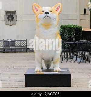 London, Großbritannien. 30.. Mai 2022. Die Menschen betrachten und fotografieren einen der riesigen Corgis, die vor der Royal Military Chapel in der Nähe der Wellington Barracks in Westminster installiert sind. Der Corgi Trail, auch bekannt als 'The Queen & her Corgis', ist ein Kunstprojekt, das aus 19 riesigen Corgi-Statuen besteht, die während des Jubiläums von zeitgenössischen Künstlern in öffentlichen Räumen platziert wurden. Kredit: Imageplotter/Alamy Live Nachrichten Stockfoto