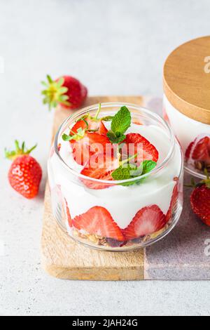 Erdbeerparfait mit Joghurt und Müsli in einem Glasgefäß. Gesundes Frühstücksrezept. Sommerliches Dessert-Konzept. Stockfoto