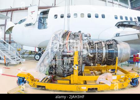 Nahaufnahme eines Turbofan-Triebwerks mit hohem Bypass in der Nähe eines Passagierflugzeugs in einem Hangar Stockfoto