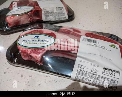 Seattle, WA, USA - ca. April 2022: Angewinkelter, selektiver Fokus auf zwei Päckchen mit frischem amerikanischem Lamm auf einer Küchentheke. Stockfoto