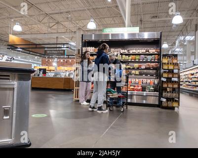 Lynnwood, WA USA - ca. März 2022: Blick auf einen Familieneinkauf rund um den Hummus und Salsa Endcap in einem Stadt- und Landmarkt. Stockfoto