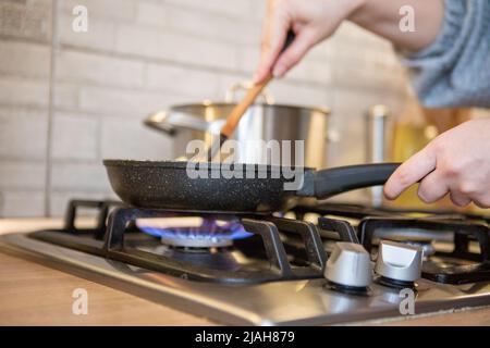 Bratpfanne auf dem Gartopf blaue Flamme aus nächster Nähe Stockfoto