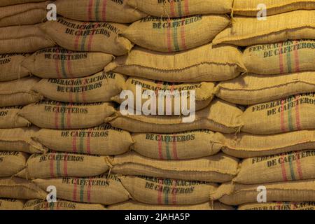 Lagerhallen, in denen Hanfsäcke mit Kaffeebohnen, der Marke kolumbianischen Kaffees, gefüllt werden. Stockfoto