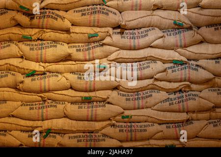 Lagerhallen, in denen Hanfsäcke mit Kaffeebohnen, der Marke kolumbianischen Kaffees, gefüllt werden. Stockfoto