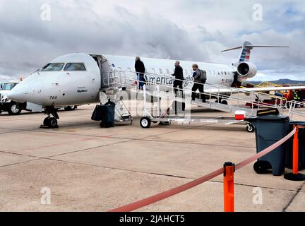 Passengerss besteigen ein von SkyWest betriebenes American Eagle Bombardier-Flugzeug am Santa Fe Municipal Airport in Santa Fe, New Mexico. Stockfoto