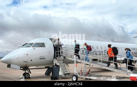 Passengerss besteigen ein von SkyWest betriebenes American Eagle Bombardier-Flugzeug am Santa Fe Municipal Airport in Santa Fe, New Mexico. Stockfoto