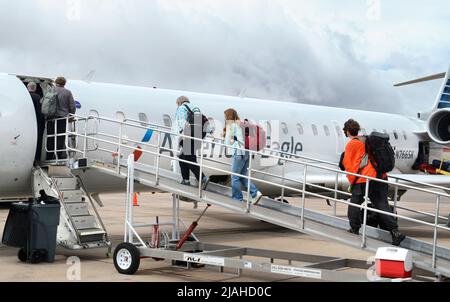 Passengerss besteigen ein von SkyWest betriebenes American Eagle Bombardier-Flugzeug am Santa Fe Municipal Airport in Santa Fe, New Mexico. Stockfoto