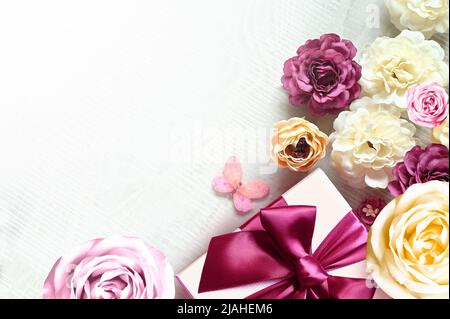 Bunte Rosen und Geschenkbox auf weißem Hintergrund. Schön, gut für Urlaub und Geschenk. Blumenmuster. Stockfoto