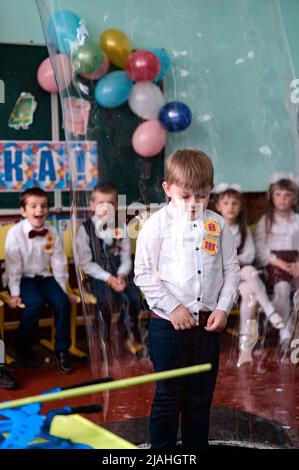 Dolyna, Ukraine 28. Mai 2021: Animatoren und Seifenblasen für einen Kinderurlaub, ein Junge macht eine große Blase auf eigene Faust, eine lustige und unterhaltsame Show. Stockfoto