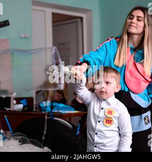 Dolyna, Ukraine 28. Mai 2021: Animatoren und Seifenblasen für einen Kinderurlaub, ein Junge macht eine große Blase auf eigene Faust, eine lustige und unterhaltsame Show. Stockfoto