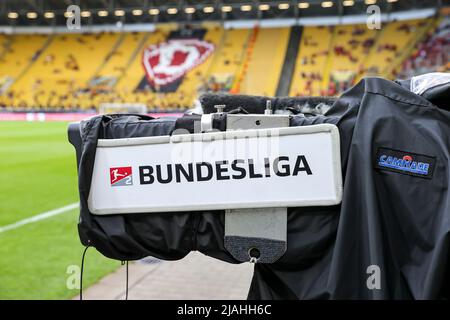 24. Mai 2022, Sachsen, Dresden: Fußball: 2. Bundesliga - Abstieg, SG Dynamo Dresden - 1. FC Kaiserslautern, zweite Etappe im Rudolf-Harbig-Stadion. An einer Fernsehkamera im Stadion hängt ein Bundesliga-Schild. Nach der Niederlage gegen Kaiserslautern wird die SGD in die Dritte Liga abgesetzt. Foto: Jan Woitas/dpa - WICHTIGER HINWEIS: Gemäß den Anforderungen der DFL Deutsche Fußball Liga und des DFB Deutscher Fußball-Bund ist es untersagt, im Stadion und/oder des Spiels aufgenommene Fotos in Form von Sequenzbildern und/oder videoähnlichen Fotoserien zu verwenden oder zu verwenden. Stockfoto