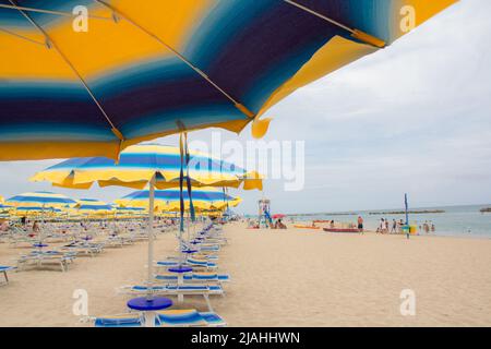 Sonnenschirme und Sofas am blauen Himmel und Meeresgrund am Strand von Italien. Beliebte Tourist Resort an der Adria am Strand von , Rimini Adriatic Stockfoto