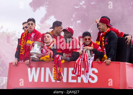 Liverpool Football Club Siegesparade durch die Straßen der Stadt, bei der der Ligapokal und die Trophäen des FA Cup gefeiert werden. Spieler im offenen Bus Stockfoto