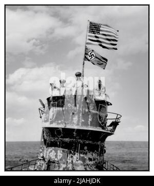 NAZI-U-BOOT US-Marineoffiziere auf dem Turm des gefangenen Nazi-deutschen U-Boots U-505 am 4. Juni 1944. Die Offiziere sind von rechts nach links: Kommandant Earl Trosino, USNR; Kapitän Daniel V. Gallery, Jr., USN, Kommandant, USS Guadalcanal (CVE-60); Und Leutnant Junior Grade Albert L. David, USN, der posthum die Ehrenmedaille für die Führung der Boarding-Party, die das U-Boot gefangen nahm und Bergungsoperationen durchgeführt erhielt. Beachten Sie die Flagge der Vereinigten Staaten, die über dem deutschen Navy-Schild mit der Kreigsmarine fliegt. U-505 war das erste feindliche Kriegsschiff, das auf hoher See gefangen genommen wurde. Stockfoto