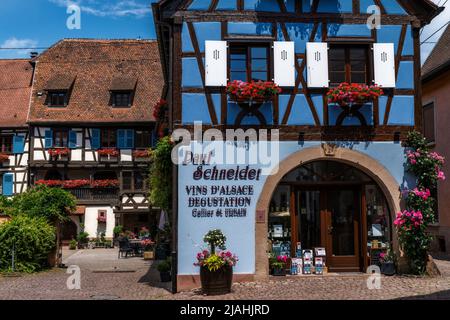 Eguisheim, Frankreich - 29. Mai 2022: Historische bunte Fachwerkhäuser und Weinkeller im Dorfzentrum von Eguisheim Stockfoto