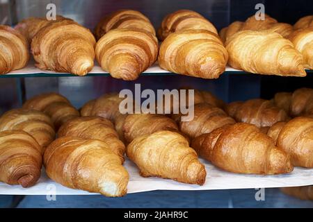 Viele frische französische Croissants im Regal Stockfoto